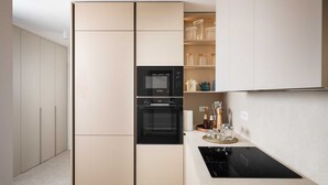 A modern kitchen with a built-in oven, a microwave, and a black induction cooktop. - B&M Adria Vista – Designer apartment in Novigrad (Novigrad)