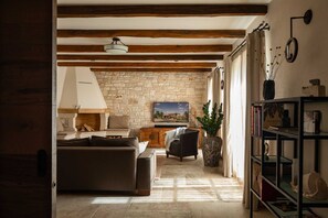 Cozy living room with a fireplace, sofa, armchairs, and a bookshelf.