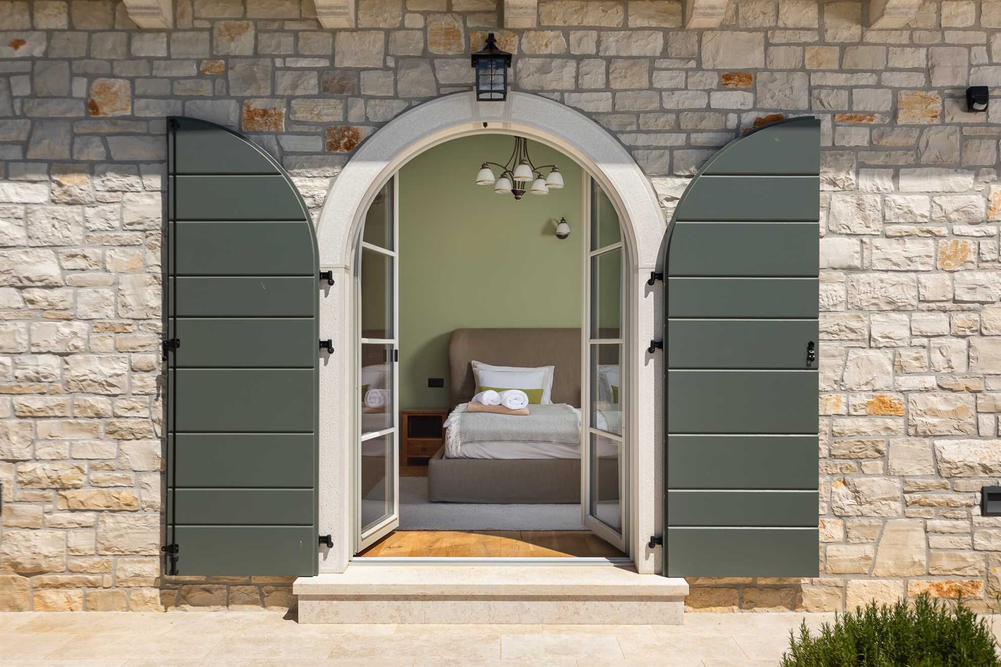 A bedroom with a bed, pillows, and a nightstand.