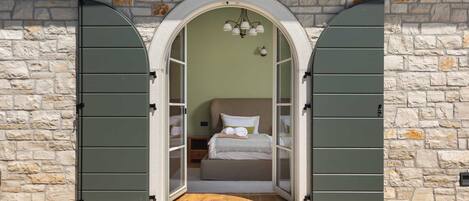 A bedroom with a bed, pillows, and a nightstand.