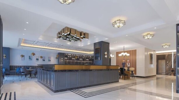 En modern hotellobby med en receptionsdisk, en sittgrupp och dekorativ belysning.