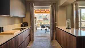 Une cuisine moderne avec des meubles en bois, un plan de travail et une vue sur un espace patio aménagé avec une table et des chaises.