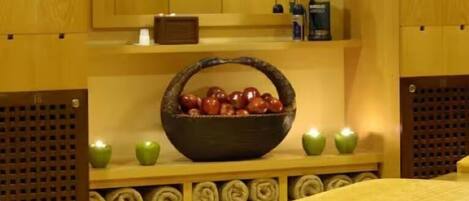 A spa room with wooden panels, a large bowl of apples, and a bench.
