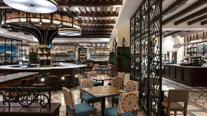 Amplio bar con diversas opciones de asientos, como taburetes y mesas, junto con una variedad de equipos y decoración.