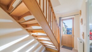 Een houten trap met uitzicht buiten door een deur.