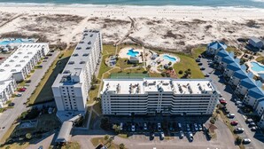 Un grand hôtel avec de nombreuses piscines, une plage et un parking.