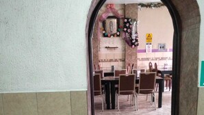 An entrance to a dining area with a tiled floor, a black doormat, and a tiled wall. - HOTEL ECONOMICO (Tijuana)