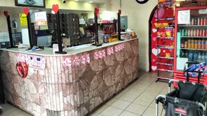 A reception area with a counter, a clock, and a vending machine. - HOTEL ECONOMICO (Tijuana)
