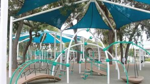 Un parque infantil con columpios y estructuras para escalar.