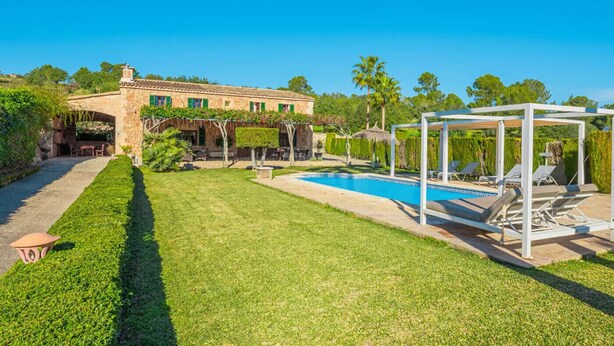 A villa with a swimming pool, outdoor seating, and a well-maintained garden. - Villa es Rafal by Mallorca North Villas  (Santa Margalida)