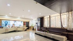 A modern hotel lobby with a reception desk, seating area, and large windows. - Lemon Hotel (Karamay Dushanzi) (Karamay)