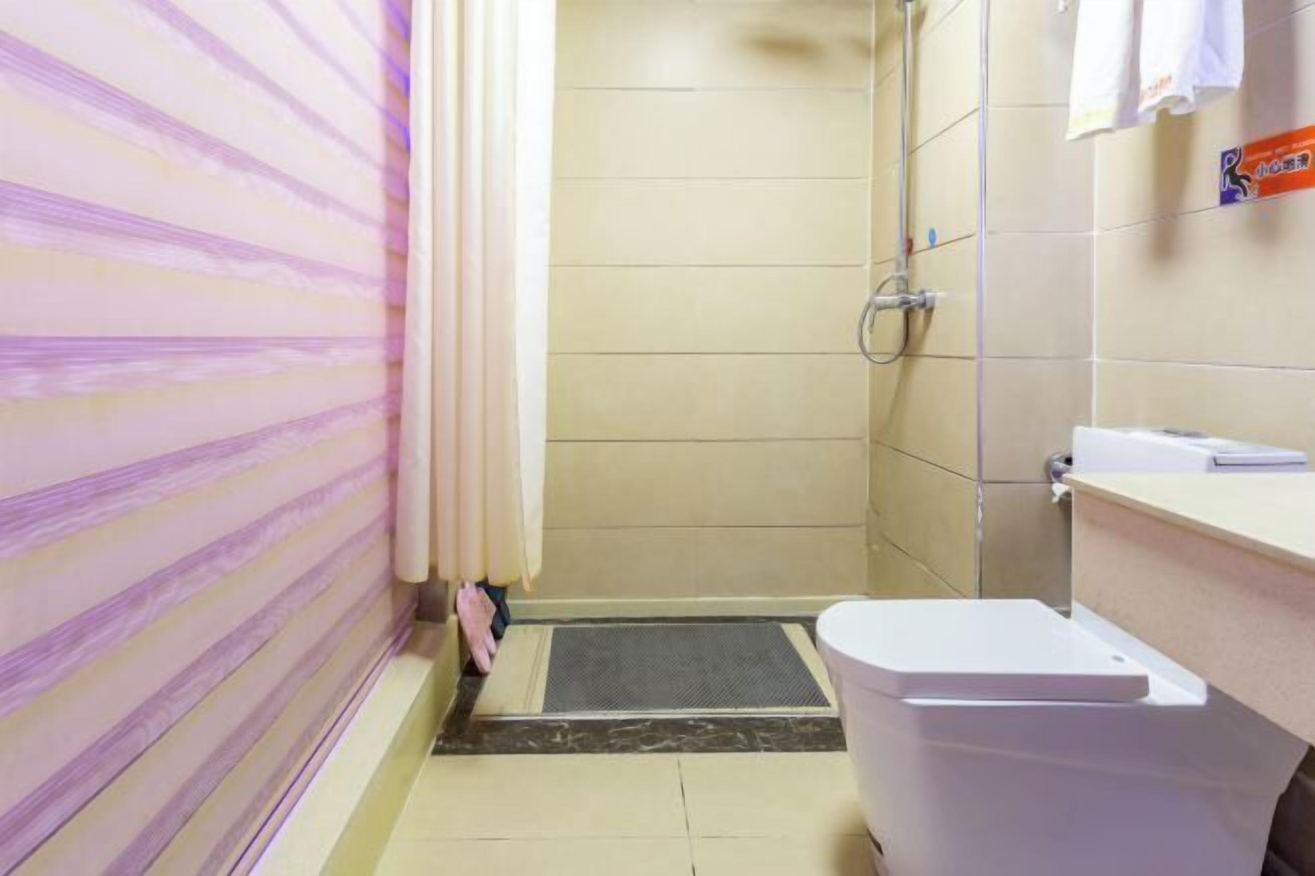 A bathroom with a shower, toilet, and sink.