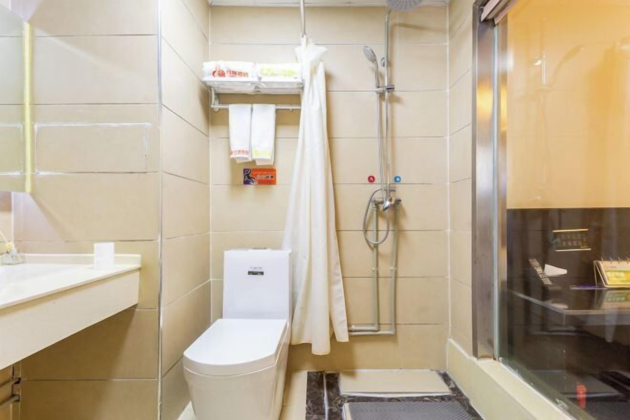 Ein kleines Badezimmer mit Toilette, Dusche und Handtuchhalter.