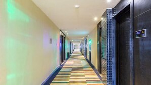 A hotel hallway with a colorful striped carpet, doors on the right, and a sign indicating room number 317. - Lemon Hotel (Karamay Dushanzi) (Karamay)