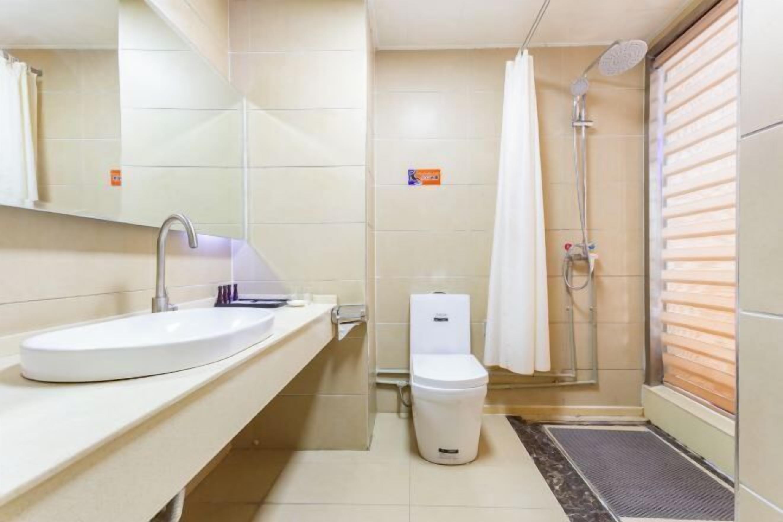 A bathroom with a sink, toilet, shower, and a towel rack.