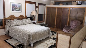 Une chambre à coucher comprenant un lit, une table de chevet, une lampe, une commode et une chaise.