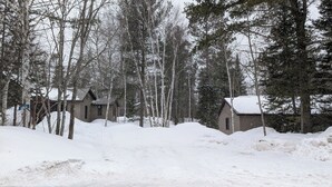 Une cabane entourée d’arbres couverts de neige.
