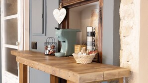 A wooden table with a coffee maker, a basket of items, and a heart-shaped decoration. - Lo Raconet dárnes, a rural apartment in the historical center of Arnes. (Arnes)