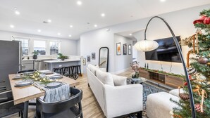 A modern kitchen with a dining area, a sofa, and a TV. - Spacious 4-bedroom apartment in Boston (Boston)