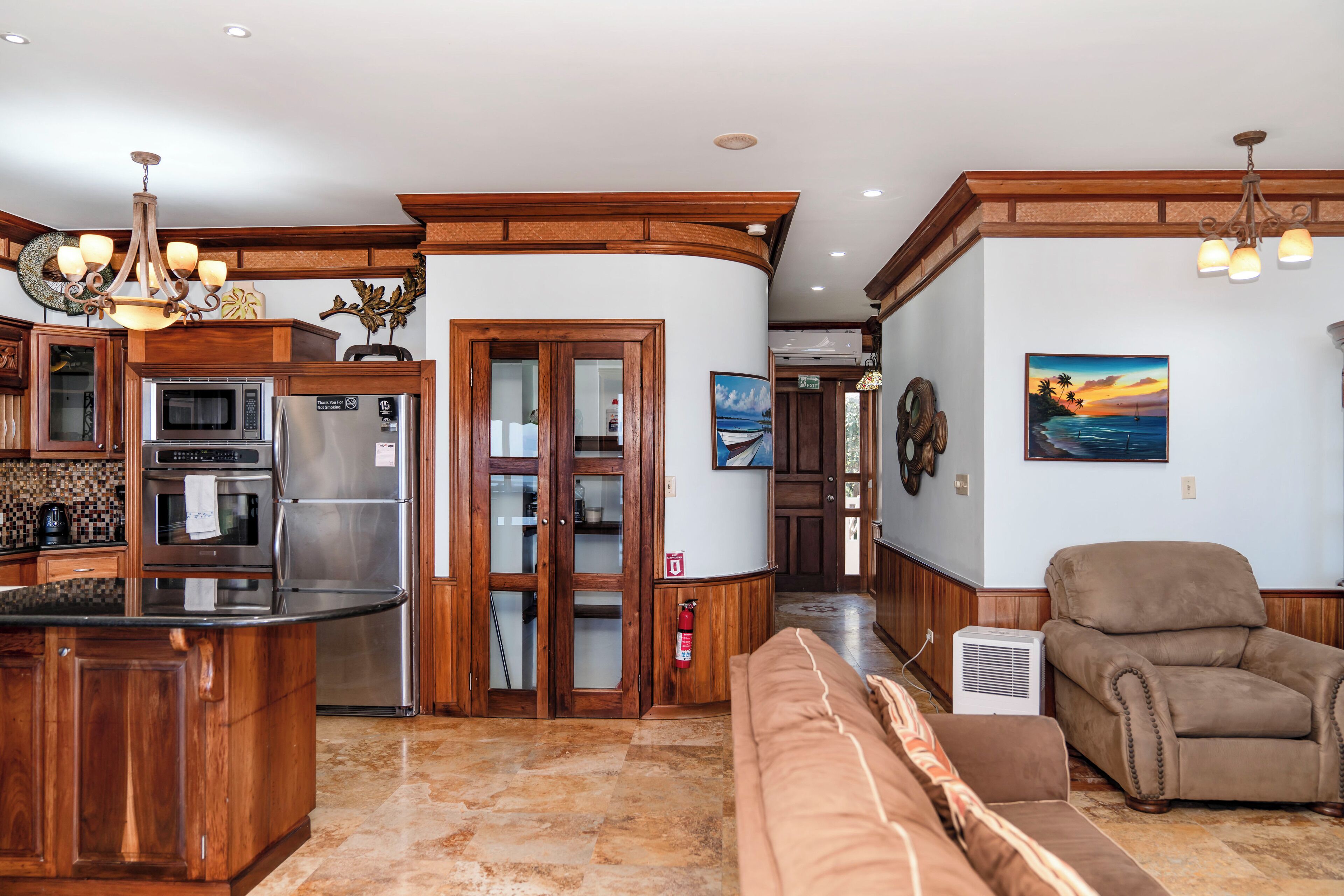 A spacious living area with a kitchen, a fireplace, and a large window.