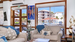 A hotel lobby with a large window, a sofa, a coffee table, and a painting of seahorses. - Luxury Beachfront Condo - Condo 17 at Oceans 23, Belize (San Pedro)