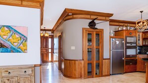 Une cuisine moderne avec des meubles en bois, un îlot central et des appareils électroménagers en acier inoxydable.