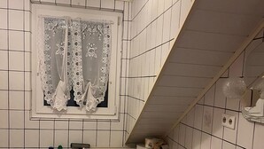 Ein kleines Badezimmer mit Badewanne, Toilette und Waschbecken.