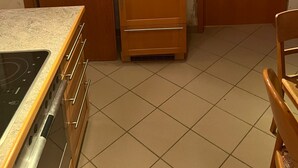 Eine kleine Küche mit Herd, Schränken und Kühlschrank.