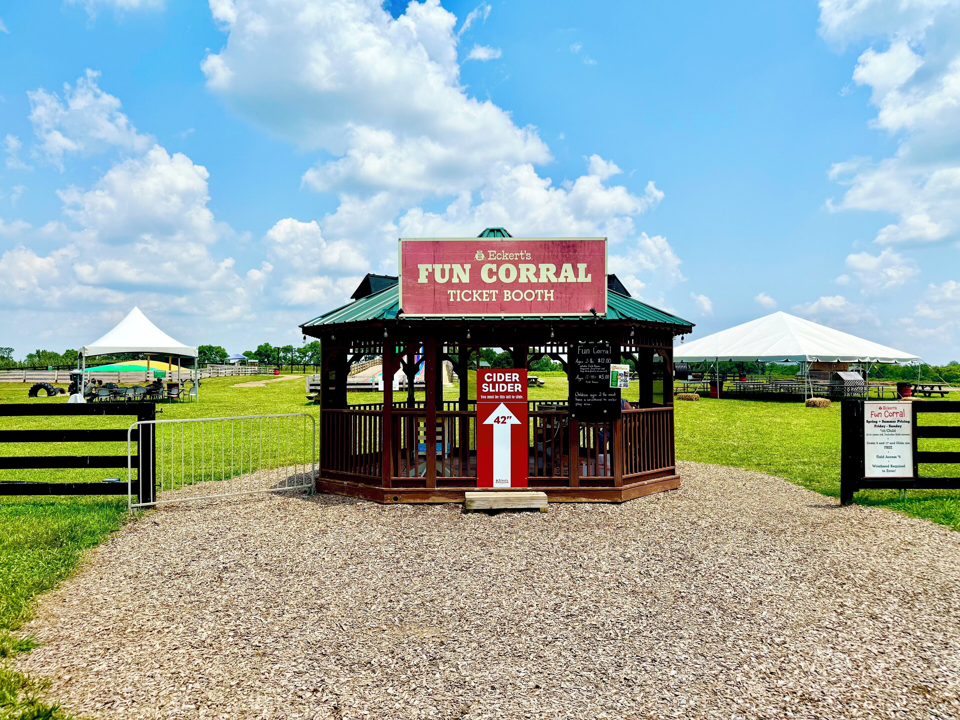 Een vrolijk loket van Fun Corral met een bord waarop een cider slider en een lengtebeperking van 42 inch vermeld staan.