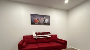 A modern living room with a red sofa, a wooden coffee table, and a wall-mounted artwork. - Beautiful House in mont tremblant,ski hills,

You will feel like you’re at home. (Mont-Tremblant)