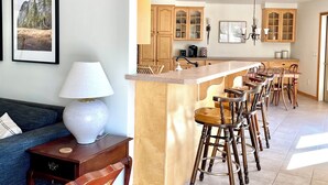 Una cocina moderna con armarios de madera, una barra con taburetes y una mesa de comedor.