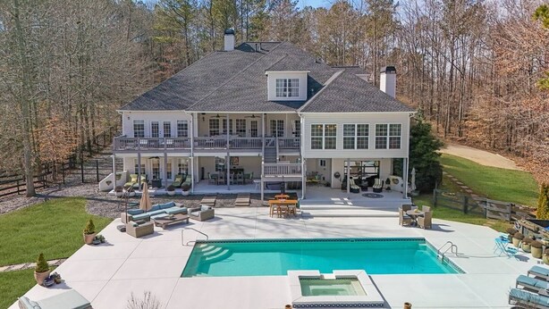 A two-story house with a large backyard, a swimming pool, and a covered patio area. - Serene Farms Hot Tub Pool Sunroom on 7 Acres (Hiram)