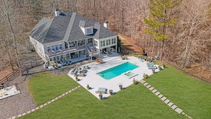 A large house with a swimming pool, surrounded by a well-maintained lawn and a wooden deck. - Serene Farms Hot Tub Pool Sunroom on 7 Acres (Hiram)