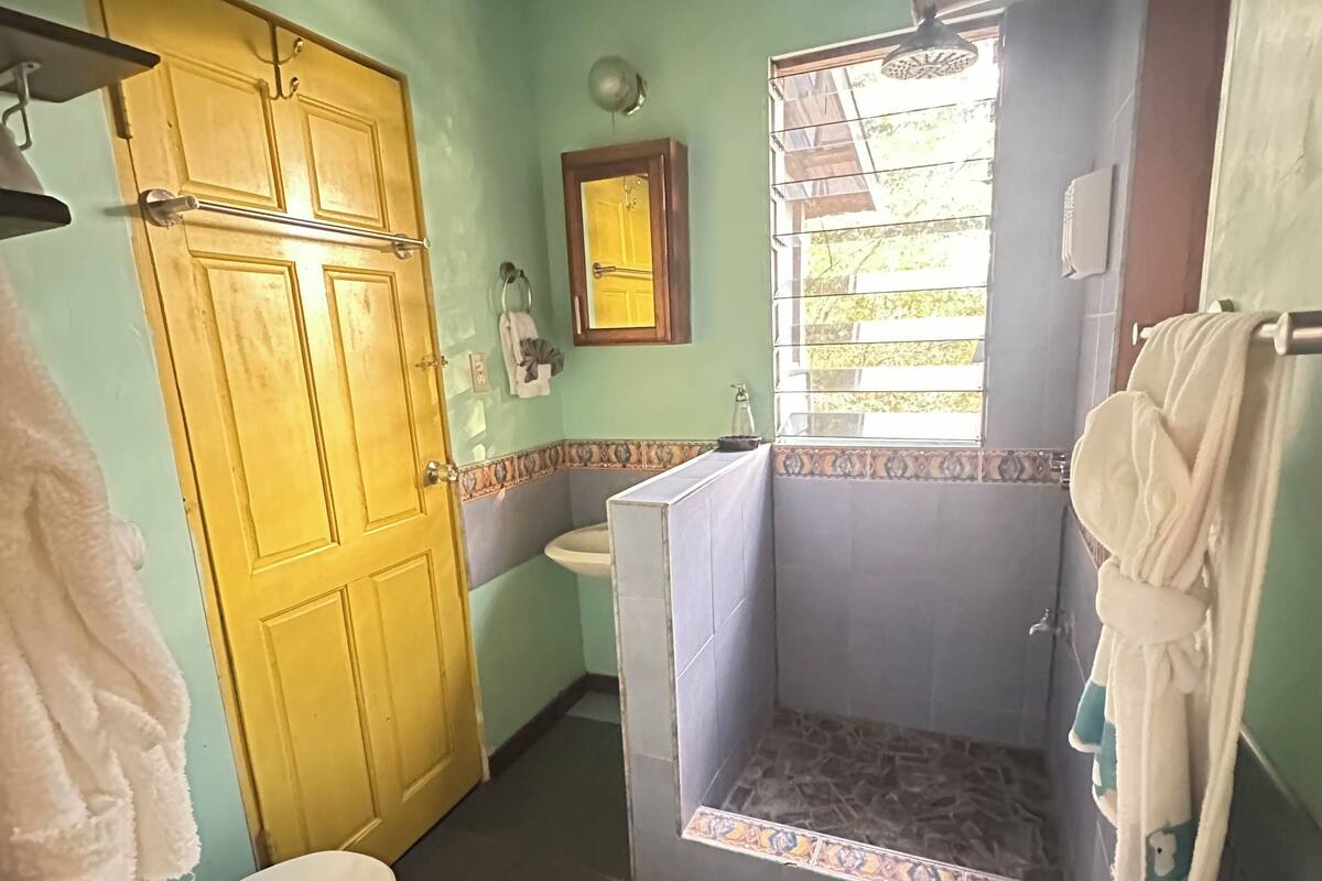 Casa de banho com sanita, lavatório e zona de duche.