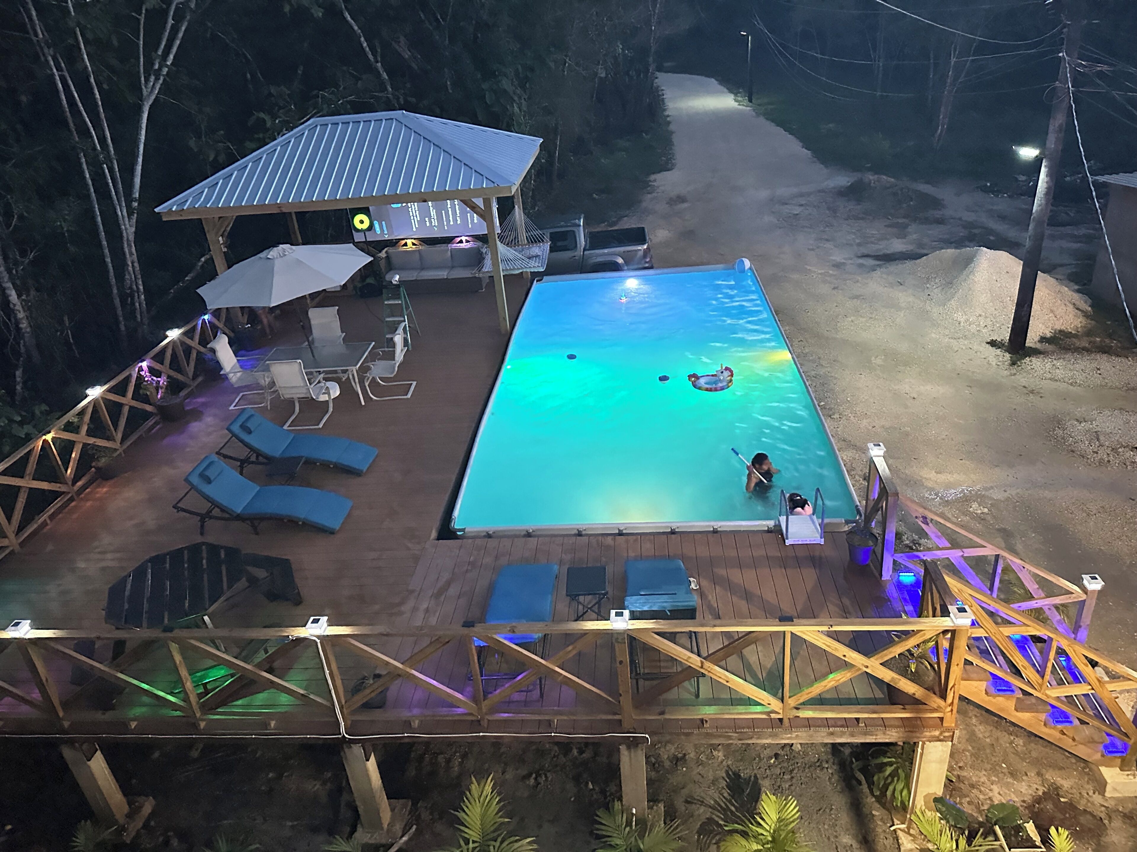 Une piscine extérieure avec des chaises longues et un espace salon abrité.
