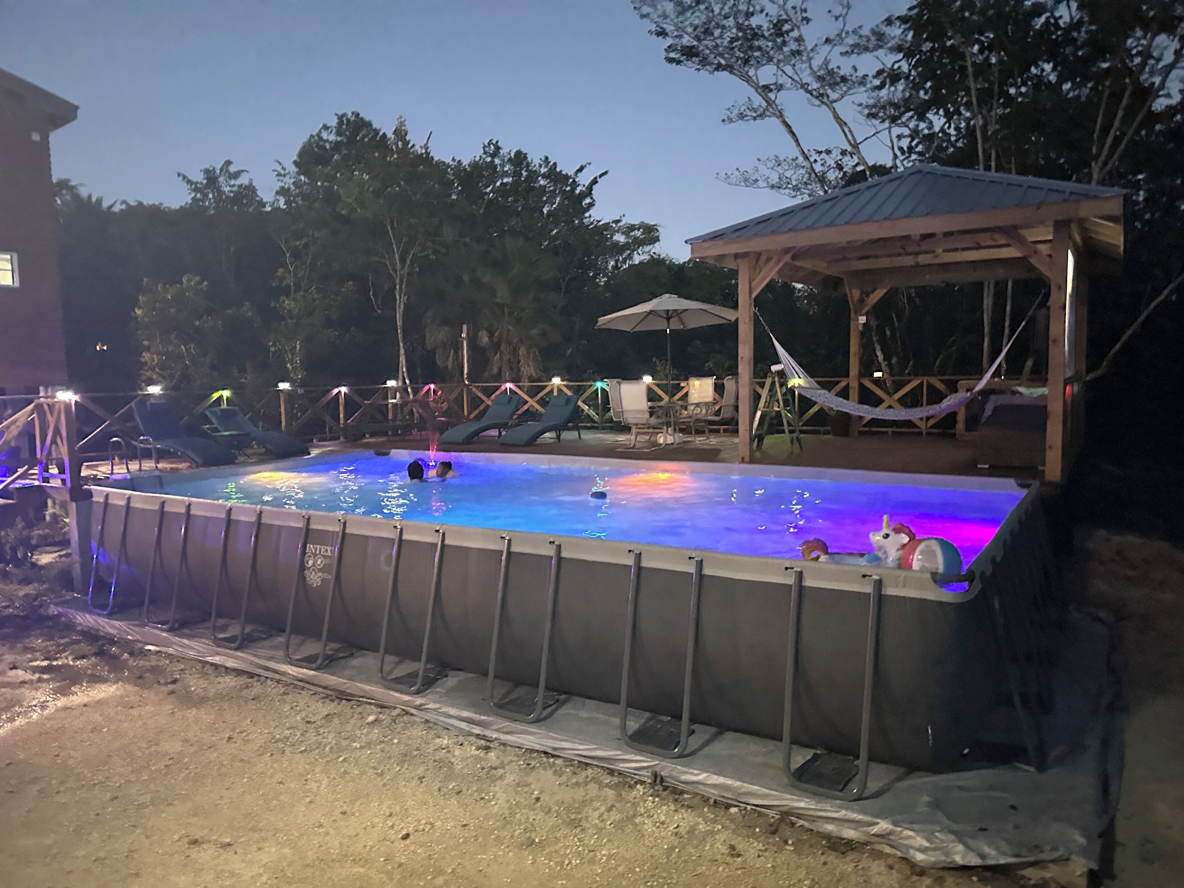 Una piscina al aire libre con cubierta de madera y sillones de descanso.