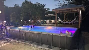 Una piscina al aire libre con cubierta de madera y sillones de descanso.