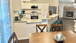 A modern kitchen with white cabinets, stainless steel appliances, and a granite countertop. - Refuge by Southern Oaks. Charming 3 bed 2 bath. Very close to Lake Murray! (Gilbert)