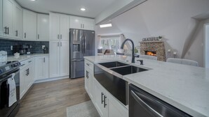 Una cocina moderna con gabinetes blancos, electrodomésticos de acero inoxidable y una isla grande.