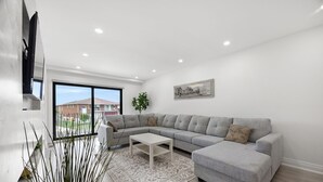 A modern living room with a grey sectional sofa, a white coffee table, and a patterned rug. - Luxury 3 BDRM Home In Toronto Ontario (Toronto)