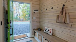 A wooden cabin interior with a bench, a sign, and storage baskets.