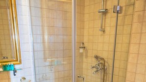 Un baño moderno con cabina de ducha de vidrio, un lavamanos blanco y un inodoro.