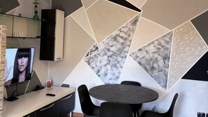 Un comedor moderno con ventilador de techo, televisor y una mesa con sillas.
