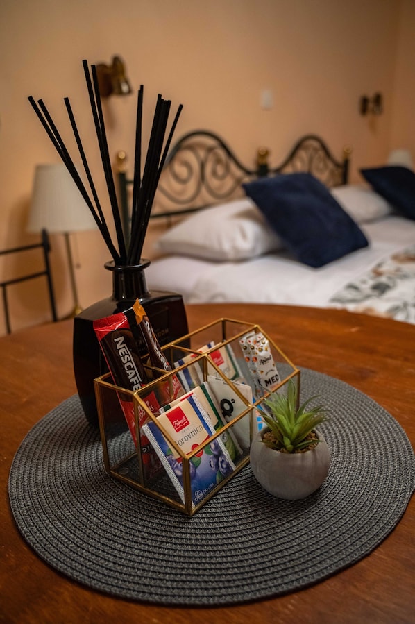 A neatly arranged table with a magazine rack, a small potted plant, and a Nescafé coffee maker.
