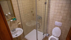 Une salle de bain avec une douche à parois de verre, un lavabo et des toilettes.
