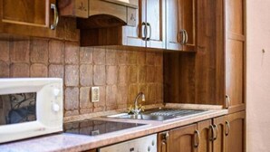 A kitchen with wooden cabinets, a built-in oven, and a microwave.