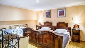A bedroom with a wooden bed, a chair, and two bedside tables.