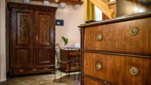 A wooden dresser with drawers and a mirror, a wooden door with intricate carvings, and a dining table with chairs.