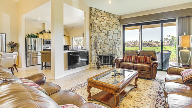 A spacious living area with leather sofas, a coffee table, and a stone accent wall. - Community Pools & Golf Views: Palm Desert Condo! (Palm Desert)