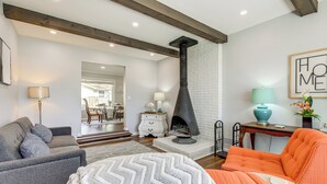 Una sala de estar con chimenea, un sofá, un sillón y una mesa.